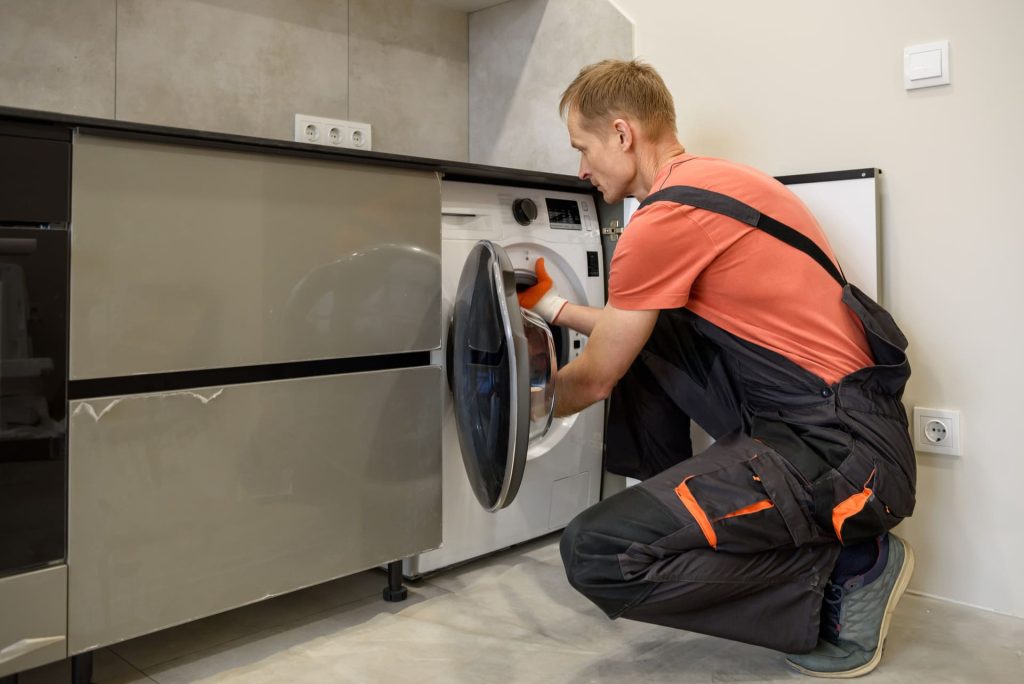 worker-installing-washing-machine-kitchen-furniture